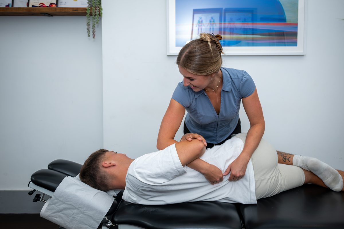 Anya adjusting a patient on the treatment couch